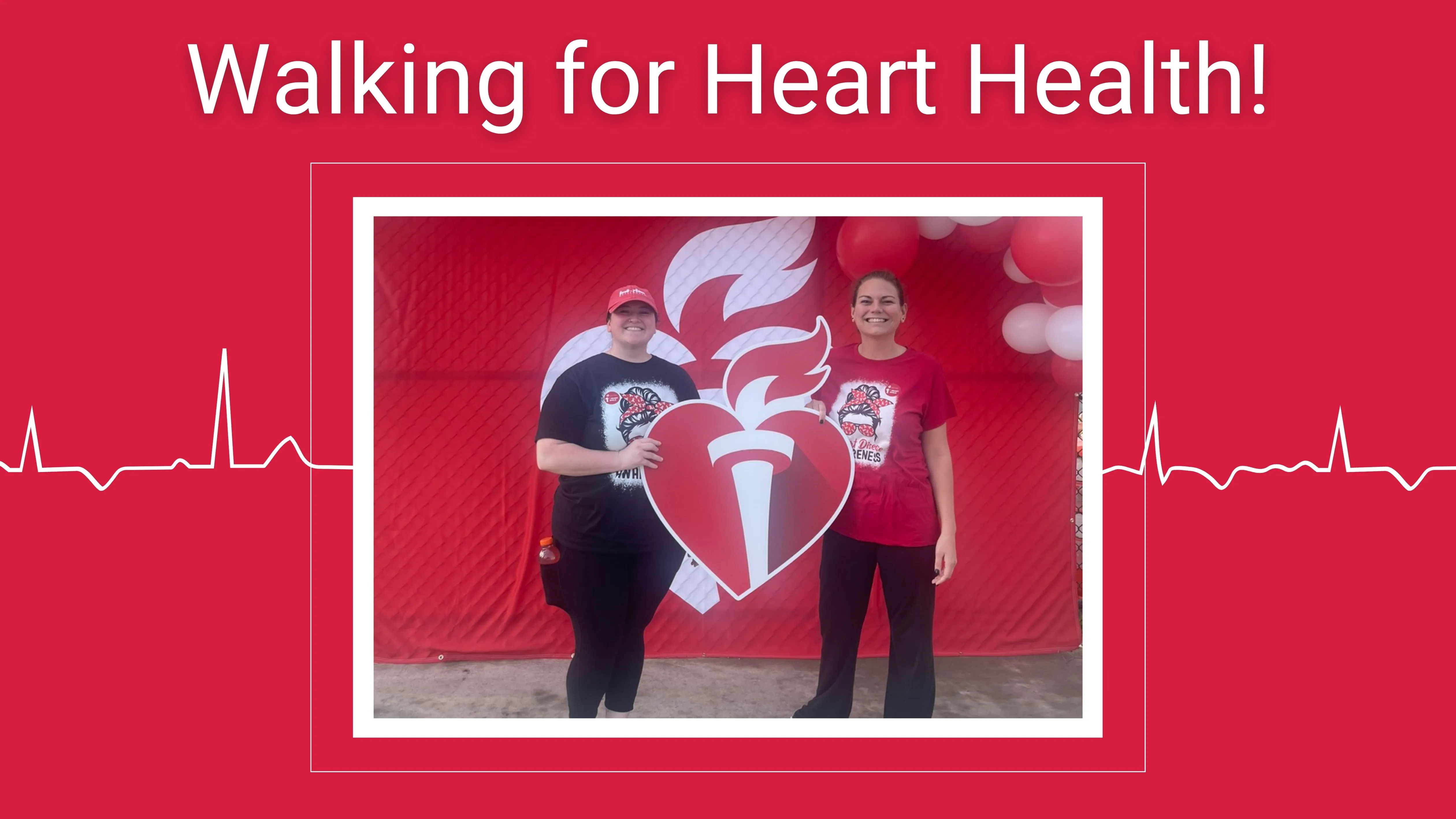 Two Interim HealthCare of the Midlands nurses stand together smiling and holding the American Heart Association symbol.